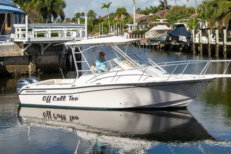 The Image of 2001 Grady-White Express 265 boat docked in a scenic canal setting. - 1