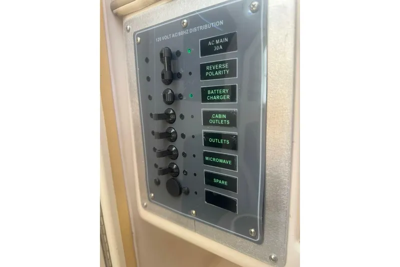 Slide: The Image of Electrical panel on a 2001 Grady-White Express 265 boat, showing various switches. - 12