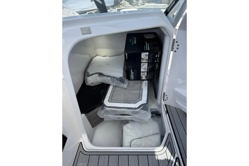 Slide: The Image of Storage compartment of 2026 Yamaha Boats 275SD, containing packaged items and accessories. - 18