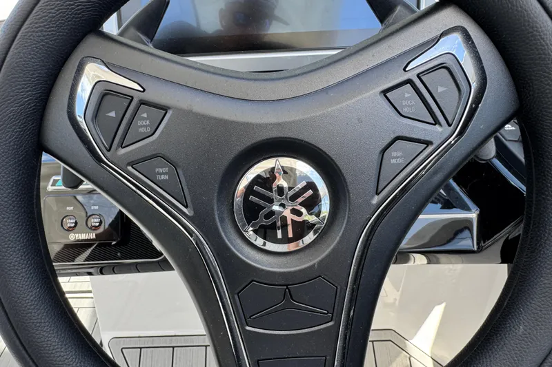 Slide: The Image of Steering wheel of 2026 Yamaha Boats 275SD with control buttons and logo. - 23