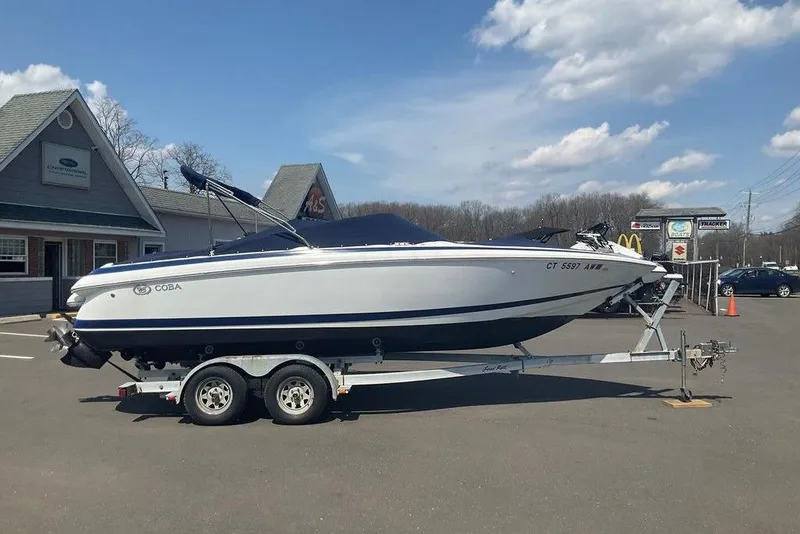 Slide: The Image of 2000 Cobalt 226 boat on trailer in parking lot, clear sky background. - 2