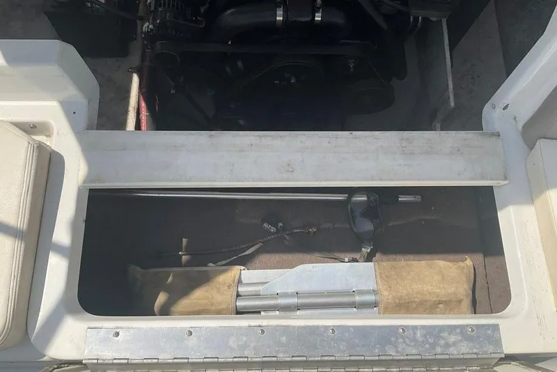 Slide: The Image of Storage compartment in a 2000 Cobalt 226 boat, showing engine and tools. - 3