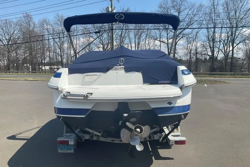 Slide: The Image of Rear view of a 2000 Cobalt 226 boat with a blue cover in a parking lot. - 5