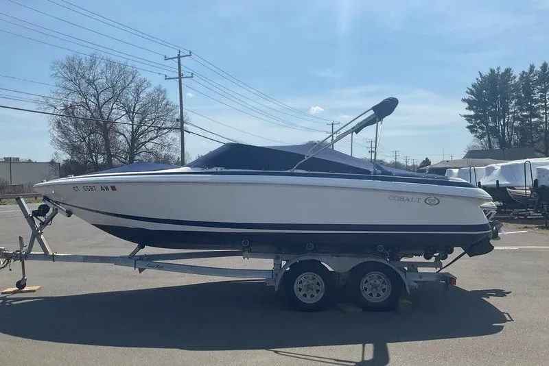Slide: The Image of 2000 Cobalt 226 boat on trailer, parked outdoors under clear sky. - 7