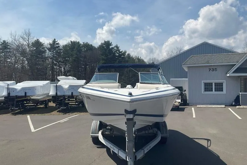 Slide: The Image of 2000 Cobalt 226 boat on trailer in parking lot, clear sky background. - 8