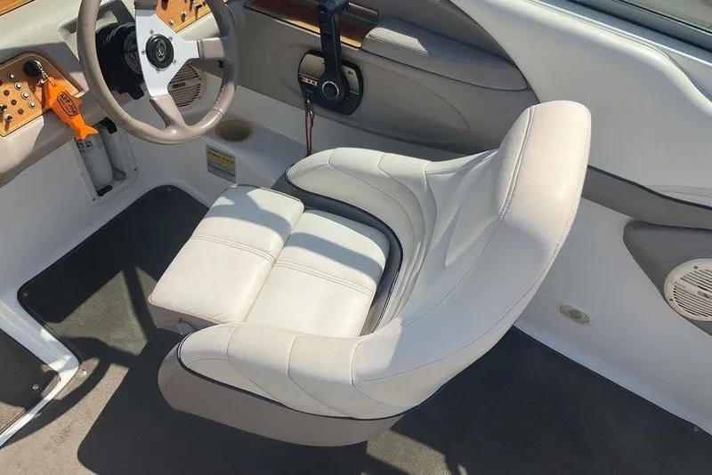 Slide: The Image of Interior of a 2000 Cobalt 226 boat featuring a white captain's chair and steering wheel. - 9