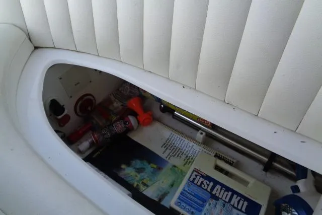 Slide: The Image of Storage compartment in a 2006 Cobalt 282 boat with first aid kit and safety items. - 29