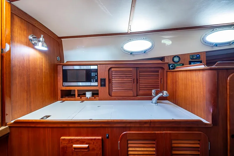 Slide: The Image of Luxurious 2011 Hinckley Picnic Boat 37 MKIII galley with wood cabinetry and modern appliances. - 16