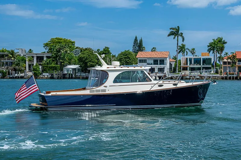 Slide: The Image of 2011 Hinckley Picnic Boat 37 MKIII cruising on a sunny day with waterfront homes in the background. - 3