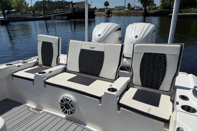 Slide: The Image of 2024 Tidewater 2700 Carolina Bay boat seats with cup holders and Yamaha engines in the background. - 10