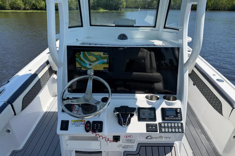 Slide: The Image of 2024 Tidewater 2700 Carolina Bay boat console with navigation display and steering wheel. - 12