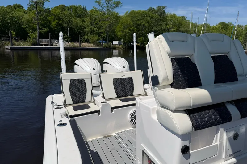 Slide: The Image of 2024 Tidewater 2700 Carolina Bay boat with dual Yamaha engines, luxurious seating, and scenic water backdrop. - 15