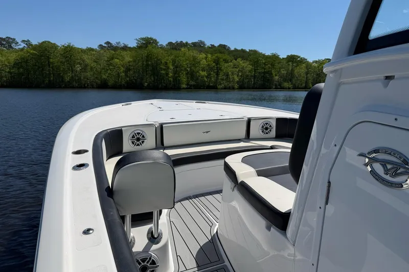 Slide: The Image of 2024 Tidewater 2700 Carolina Bay boat interior on a serene lake with lush greenery. - 17