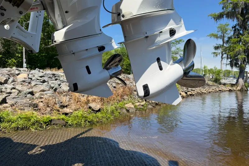 Slide: The Image of Twin outboard motors of 2024 Tidewater 2700 Carolina Bay near a rocky shoreline. - 20