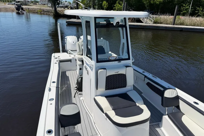 Slide: The Image of 2024 Tidewater 2700 Carolina Bay boat on calm water, showcasing sleek design and spacious seating. - 6