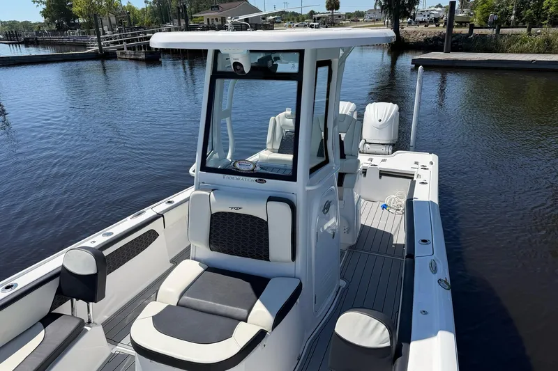 Slide: The Image of 2024 Tidewater 2700 Carolina Bay boat on calm water, featuring sleek design and spacious deck. - 7
