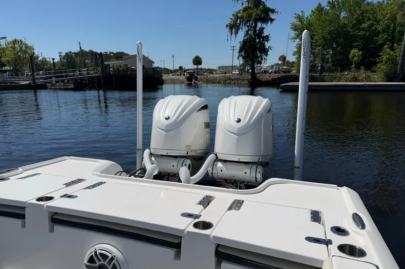 Slide: The Image of 2024 Tidewater 2700 Carolina Bay boat with dual engines on a calm waterway. - 9