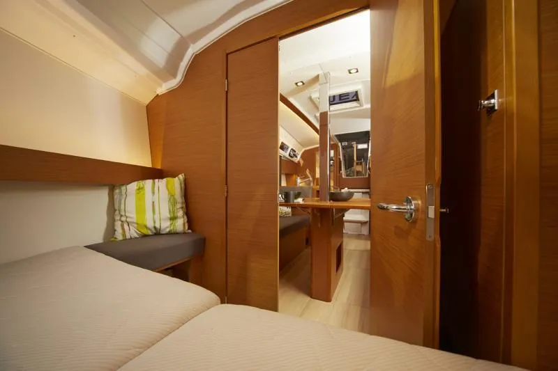 Slide: The Image of Manufacturer Provided Image: Interior cabin of 2019 Jeanneau Sun Odyssey 349 sailboat, featuring cozy bedding and wooden finishes. - 6