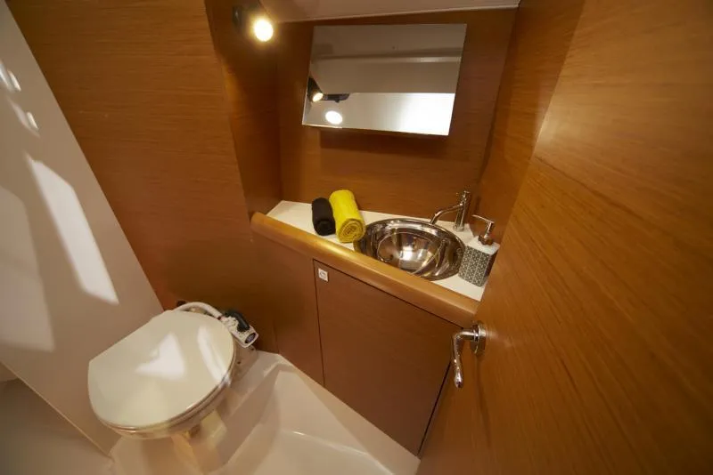 Slide: The Image of Manufacturer Provided Image: 2019 Jeanneau Sun Odyssey 349 bathroom with sink, mirror, and toilet. - 8