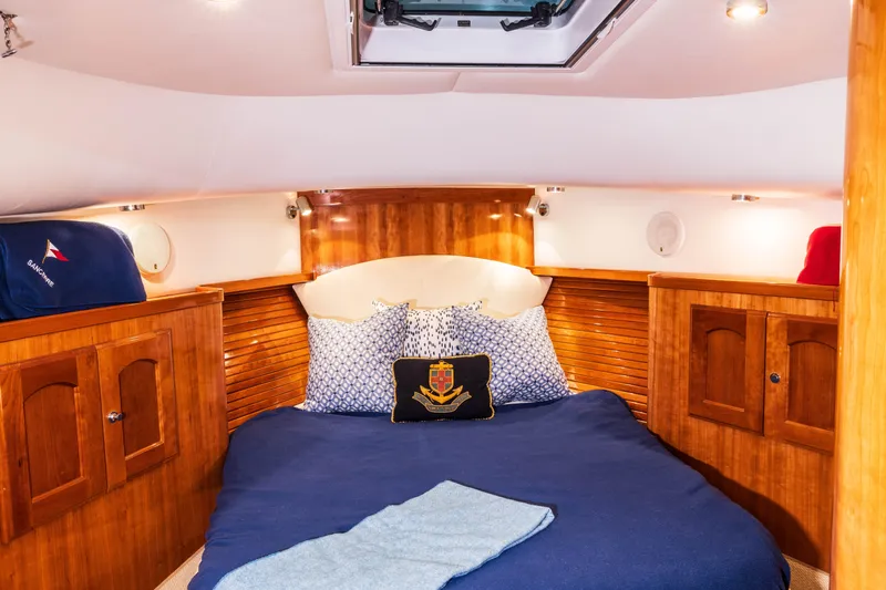 Slide: The Image of Luxurious cabin interior of 2007 Legacy 32 Express yacht with cozy bed and wooden finishes. - 11