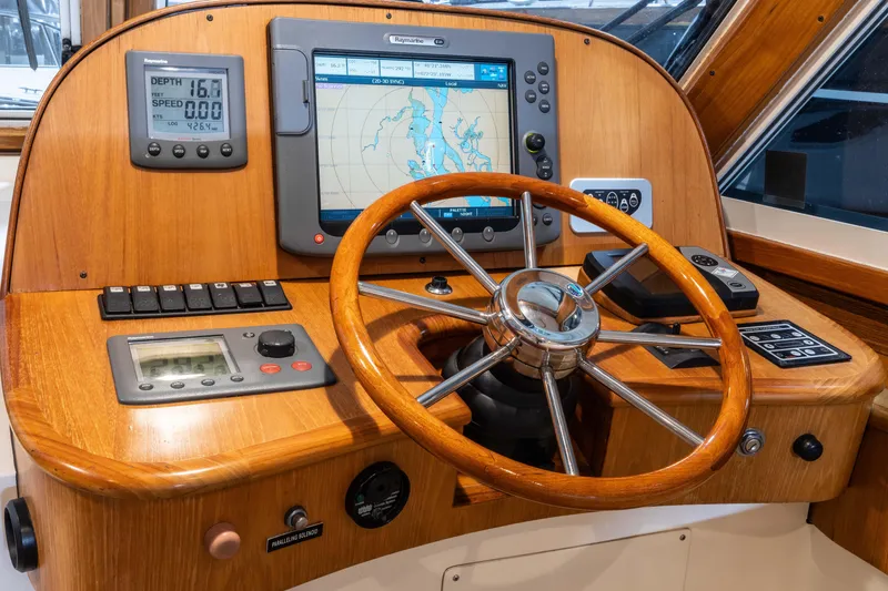 Slide: The Image of Helm of 2007 Legacy 32 Express boat with navigation instruments and wooden steering wheel. - 5