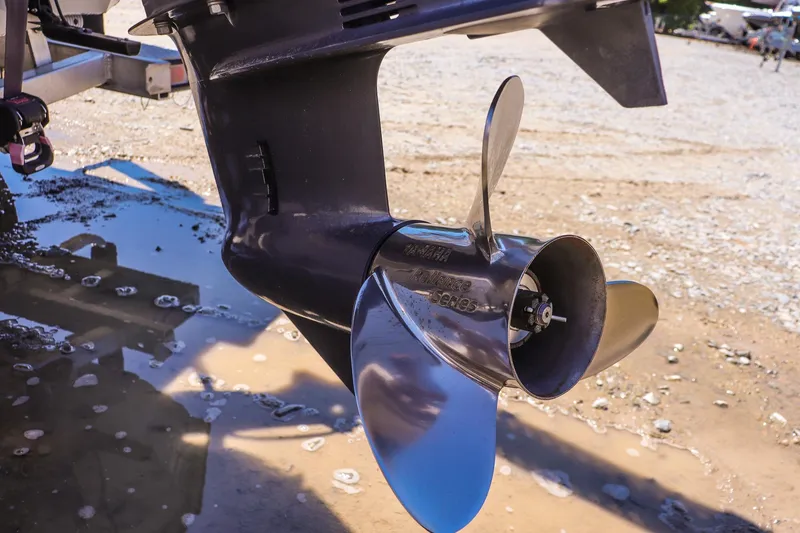 Slide: The Image of Close-up of a 2024 Avid 21 FSX boat propeller on a sandy surface. - 19