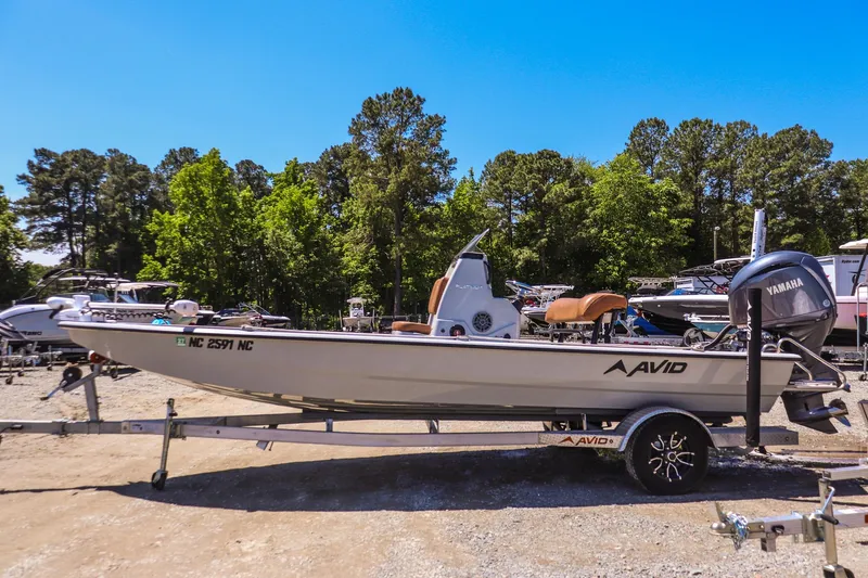 Slide: The Image of 2024 Avid 21 FSX boat on trailer, surrounded by trees and other boats. - 5