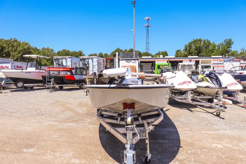 Slide: The Image of 2024 Avid 21 FSX boat on trailer in outdoor lot, surrounded by other boats. - 7