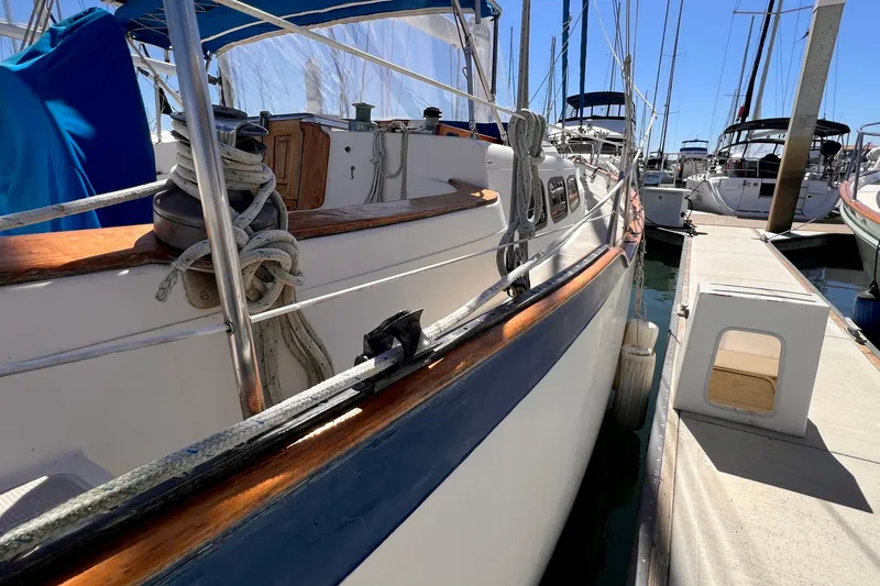 Slide: The Image of 1983 Westsail 42 Center Cockpit sailboat docked at marina, side view. - 11