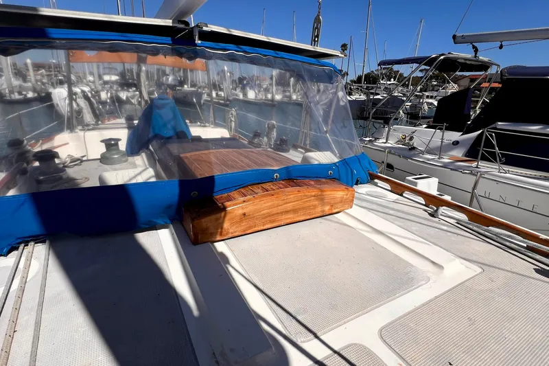 Slide: The Image of 1983 Westsail 42 Center Cockpit sailboat with blue canopy, docked in a marina. - 12