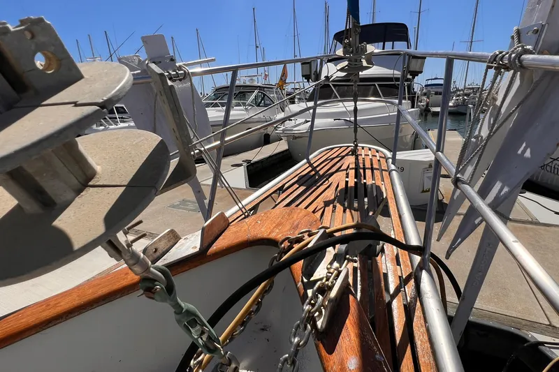 Slide: The Image of 1983 Westsail 42 Center Cockpit sailboat deck with wooden details and marina view. - 17