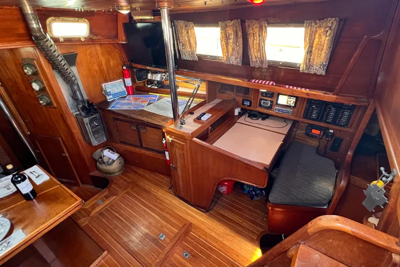 Slide: The Image of Interior of 1983 Westsail 42 Center Cockpit with wood finish and navigation equipment. - 27