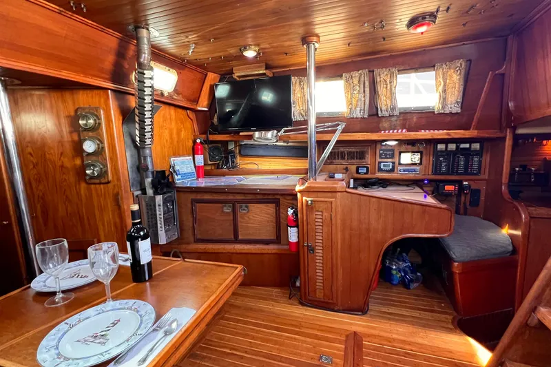 Slide: The Image of Interior of 1983 Westsail 42 Center Cockpit yacht with wood finish and dining setup. - 28