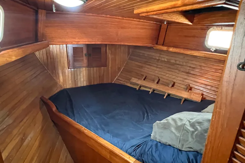 Slide: The Image of 1983 Westsail 42 Center Cockpit cabin with wooden interior and cozy bedding. - 39