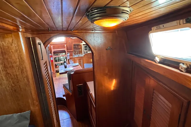 Slide: The Image of Interior of 1983 Westsail 42 Center Cockpit with wooden paneling and cozy dining area. - 40