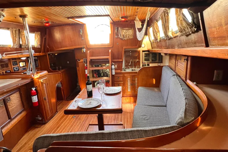 Slide: The Image of Interior of 1983 Westsail 42 Center Cockpit yacht with cozy dining area and wooden finishes. - 41