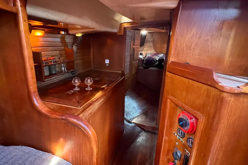 Slide: The Image of Cozy interior of 1983 Westsail 42 Center Cockpit with wooden finishes and ambient lighting. - 43