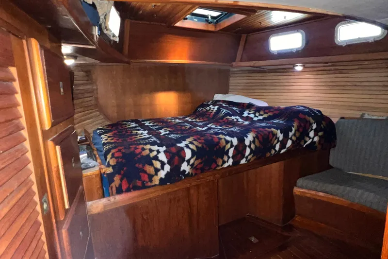 Slide: The Image of Cozy cabin interior of 1983 Westsail 42 Center Cockpit with patterned bedding. - 44