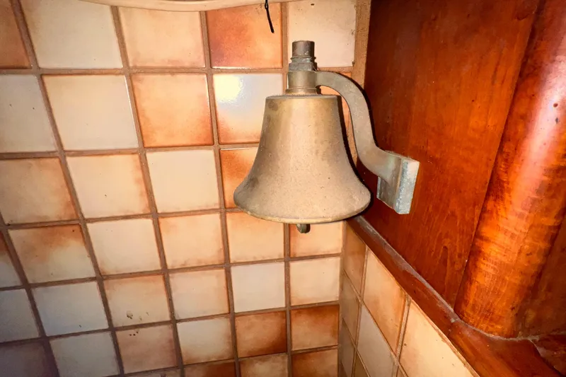 Slide: The Image of Vintage brass bell on tiled wall, Westsail 42 Center Cockpit, 1983. - 49