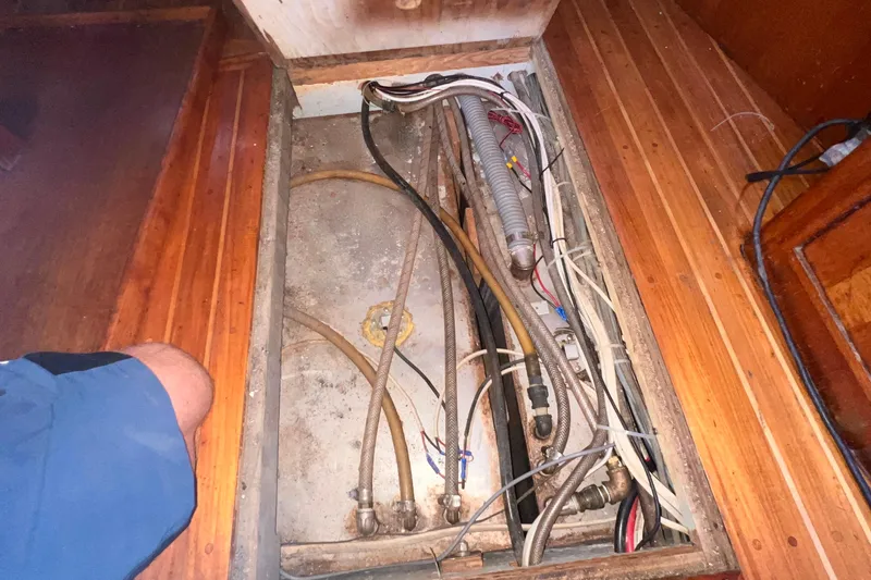 Slide: The Image of Bilge area of 1983 Westsail 42 Center Cockpit with visible wiring and hoses. - 50