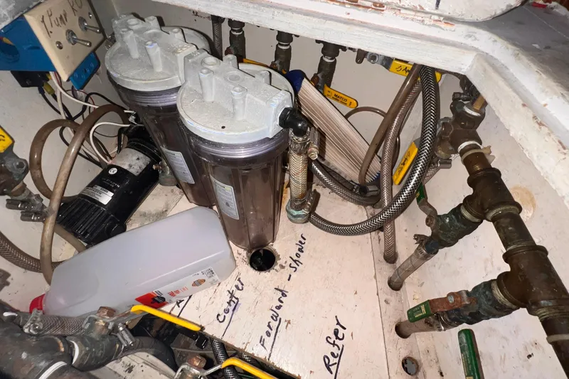 Slide: The Image of Bilge area of 1983 Westsail 42 Center Cockpit with water filtration system and plumbing. - 53