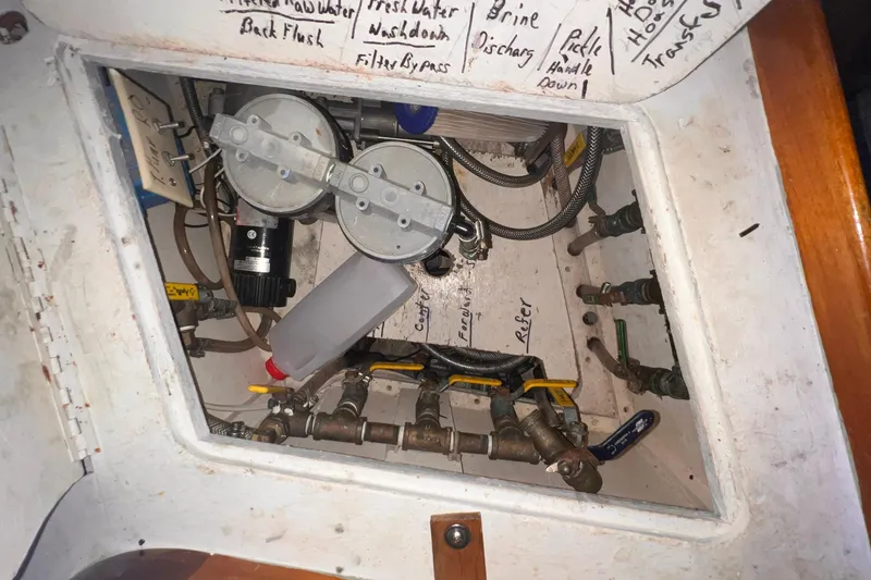 Slide: The Image of Engine compartment of 1983 Westsail 42 Center Cockpit with labeled valves and components. - 55