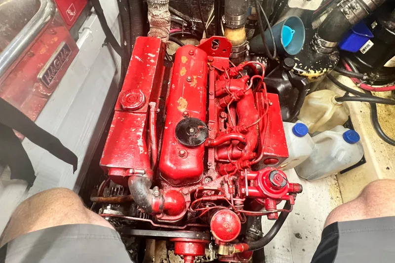 Slide: The Image of Red engine in 1983 Westsail 42 Center Cockpit sailboat, surrounded by maintenance tools. - 61