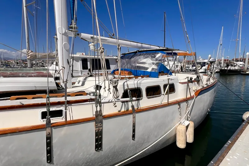 Slide: The Image of 1983 Westsail 42 Center Cockpit sailboat docked in a marina under clear blue skies. - 8
