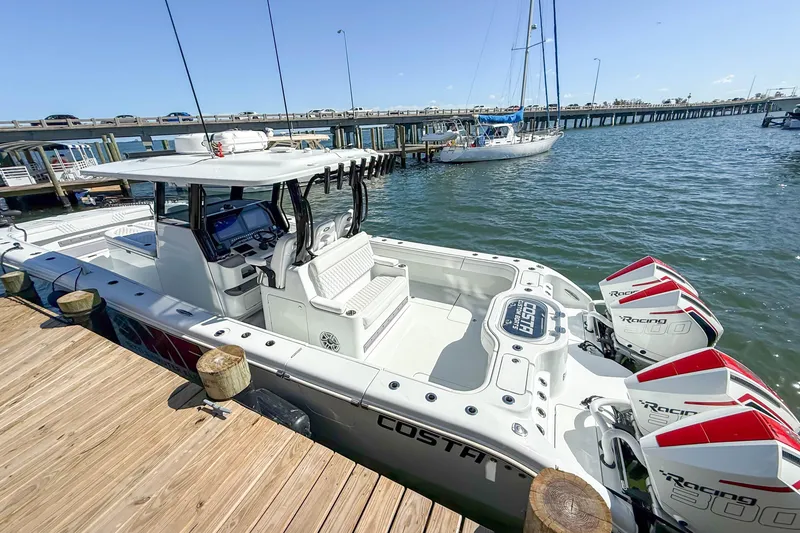 Slide: The Image of 2023 Costa Custom Boats 34 docked, featuring triple outboard engines and sleek design. - 11