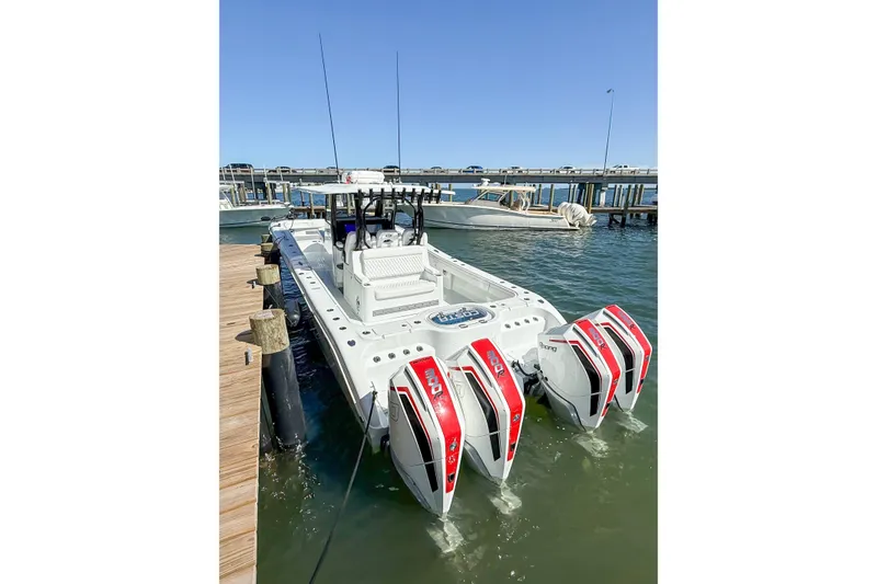 Slide: The Image of 2023 Costa Custom Boats 34 docked, featuring triple outboard engines, in a sunny marina setting. - 12