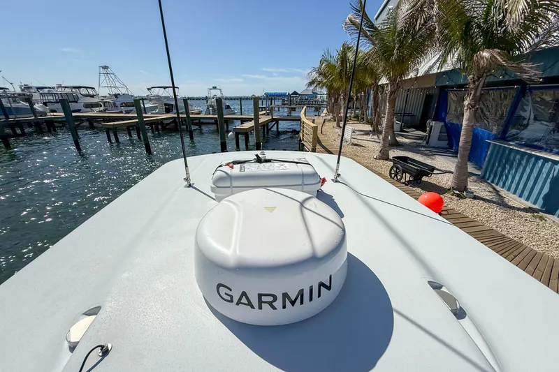 Slide: The Image of 2023 Costa Custom Boats 34 docked, featuring Garmin equipment, with marina and palm trees in background. - 13
