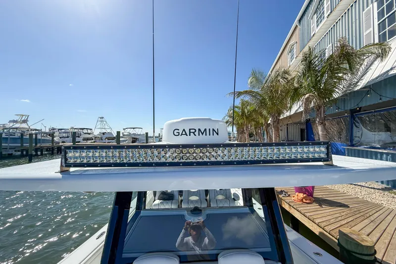 Slide: The Image of 2023 Costa Custom Boats 34 with Garmin equipment docked near palm trees. - 15