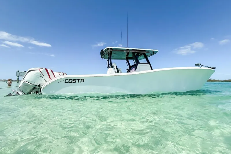 Slide: The Image of 2023 Costa Custom Boats 34 in clear turquoise water under a bright blue sky. - 2