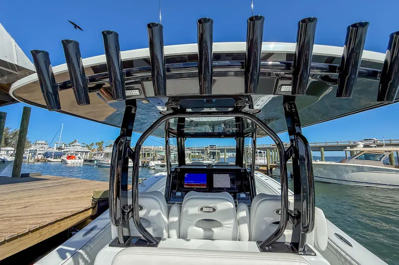 Slide: The Image of 2023 Costa Custom Boats 34 at marina, featuring advanced navigation system and rod holders. - 23
